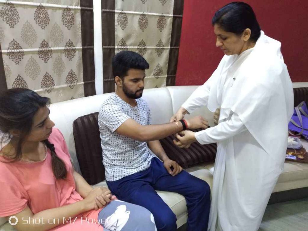 Faridabad Sec 46 - Bk Madhu bhn. tying Rakhi to the Councillor, Sis. Hema Baisla and Brother, on the occasion of Raksha Bandhan.